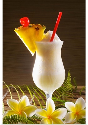 A pina colada garnished with fruit and flowers.