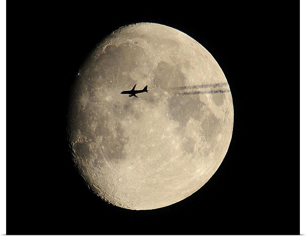plane crossing in front of moon.