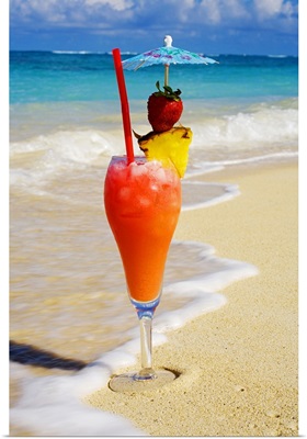 A tropical cocktail on the beach, wave washing on the sand.