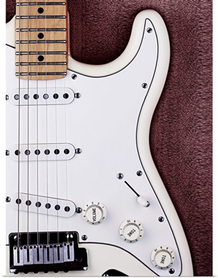 A white electric guitar on a wooden surface