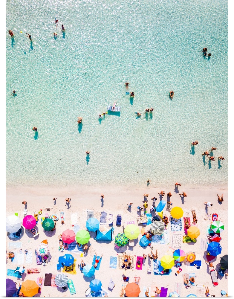Aerial view of a white beach full of colored beach umbrellas and relaxed people swimming on a clear sea. Cala Brandinchi, ...