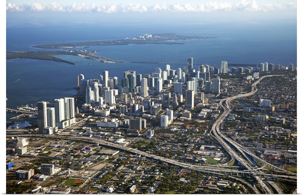 Photograph taken from above the city of Miami with the skyscrapers to the left and near the water with major highways cutt...