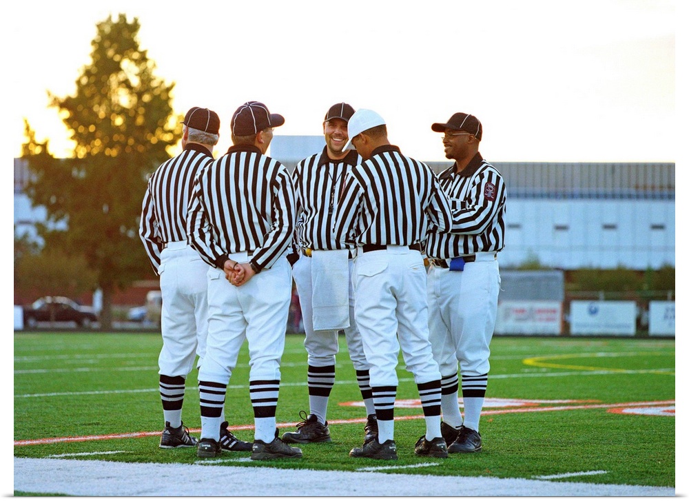 American football referees talking in field