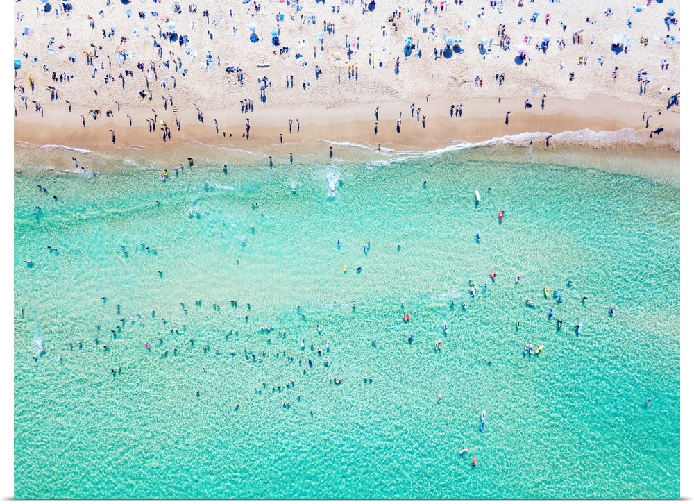 An aerial view of people at the beach. An aerial view looking down at Bondi beach in Sydney on a busy day with blue water.