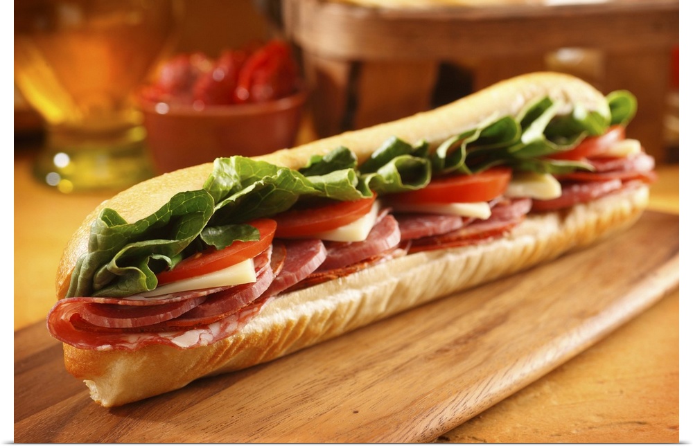 An Italian sub sandwich with ham,salami,pepperoni, Swiss cheese, lettuce and tomato on a sandwich roll.