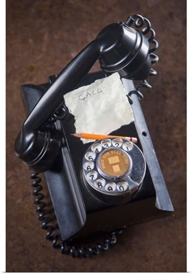 antique telephone with a piece of paper and pencil