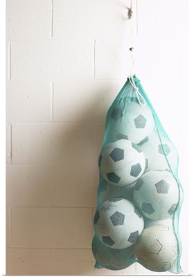 Bag of soccer balls hanging on hook
