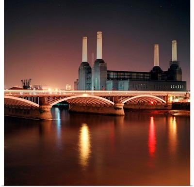Battersea Power Station at night with light reflections in river Thames.