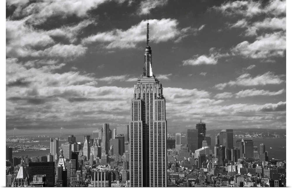 Black and white landscape photograph taken of the Empire State building with the skyline seen in the background.