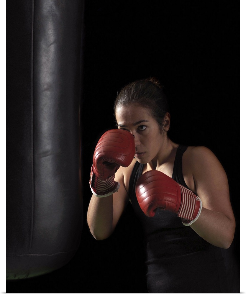 Female boxer training on punching bag