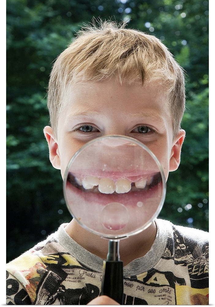 blond boy behind magnifying glass smiling