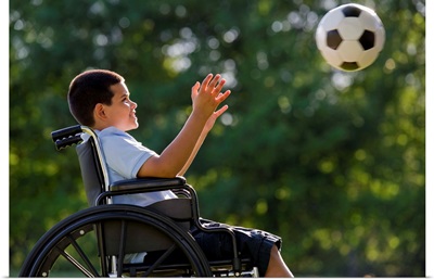 Boy in wheelchair with soccer ball