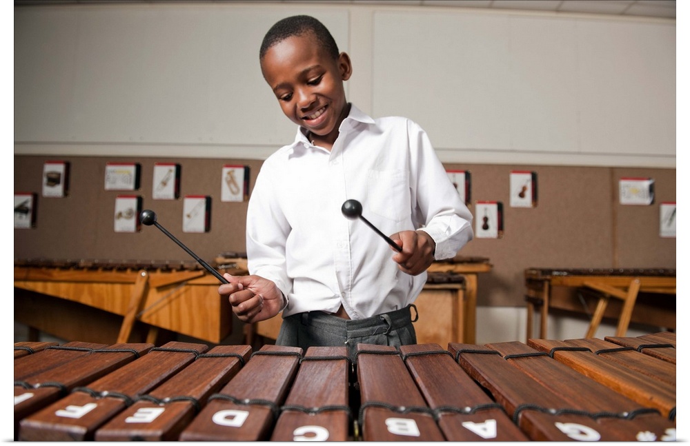 Boy playing wooden xylophone in classroom, Johannesburg, Gauteng Province, South Africa.