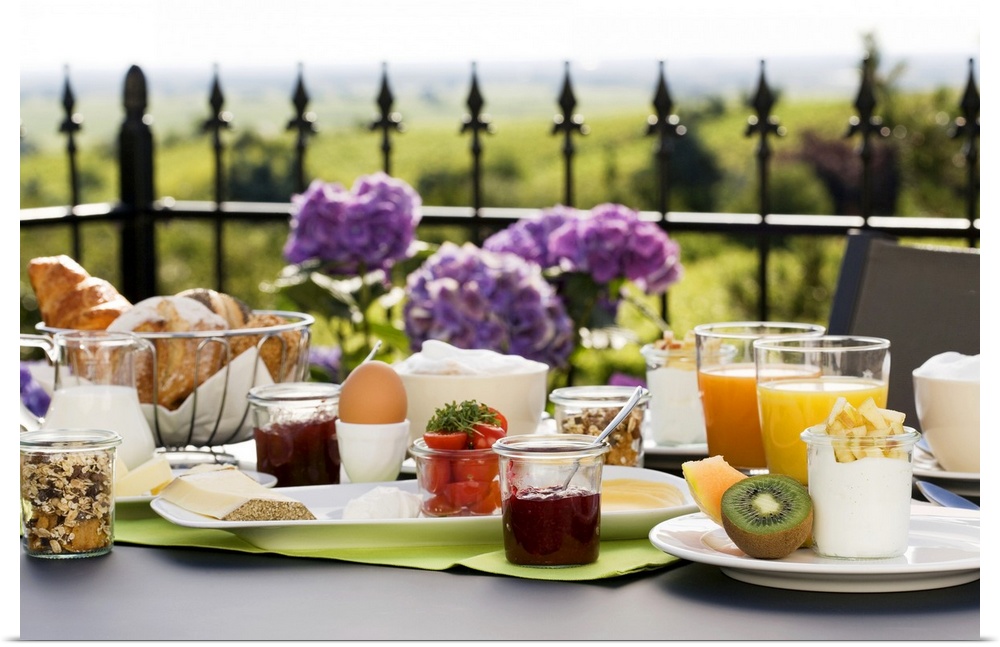 A spread of breakfast food is photographed on a table that sits on an outdoor terrace