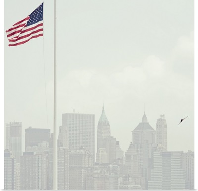Buildings of Manhattan with United States flag flying in foreground.