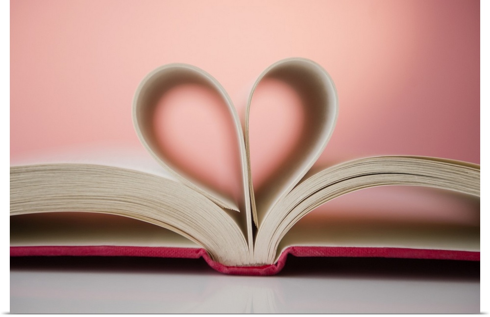 A picture taken of a book with its pages folded inward to form a heart shape.