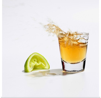 Close up of tequila splashing out of glass
