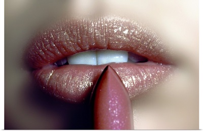 Close-up of woman applying a glitter lipstick