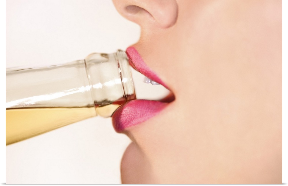 This picture is taken closely of a woman's mouth as she begins to take a sip from a bottled drink.