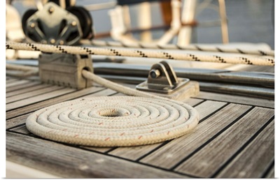 Coiled line, rope, on teak deck of 62 ft sailboat