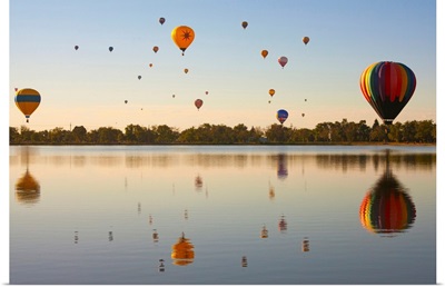 Colorful air balloons reflected in lake.