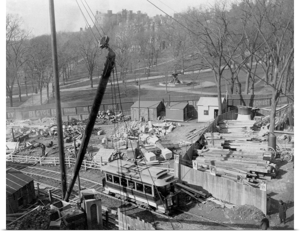 A streetcar passes by a work site on Boston Common during a construction project.