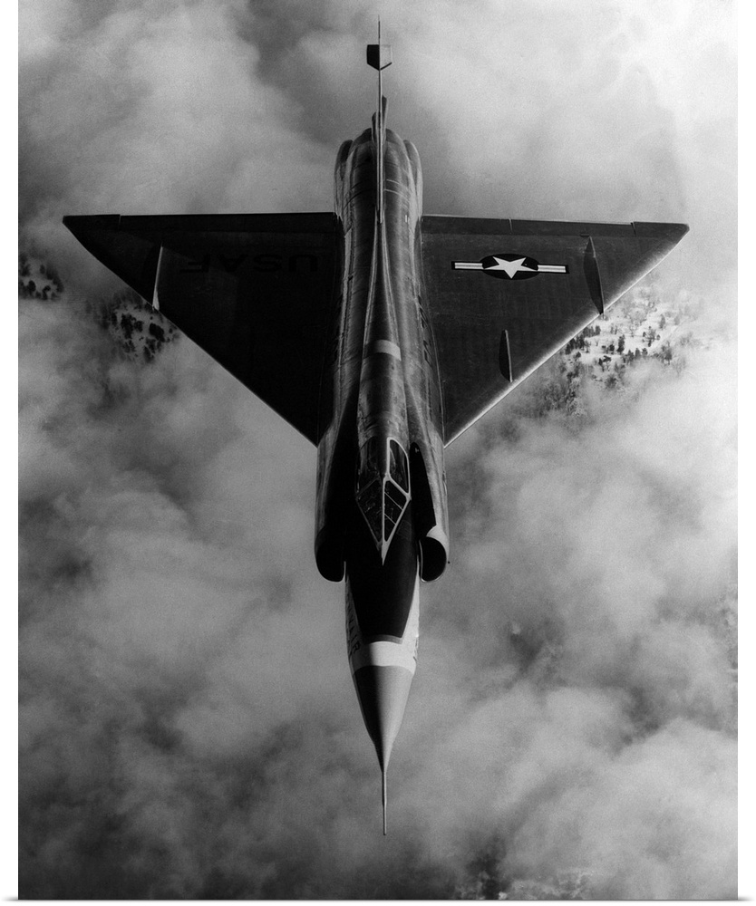 A United States Air Force, delta-wing F-102A, interceptor aircraft in flight above cloud cover.