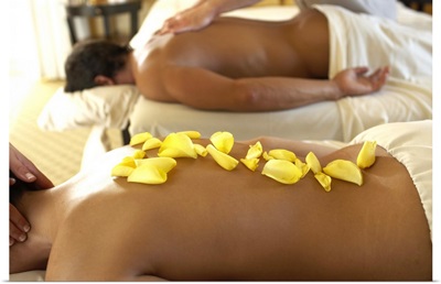 Couple receiving massage by two masseurs