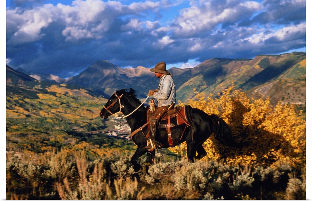 USA, Colorado, Snowmass, cowboy riding along ridge above town