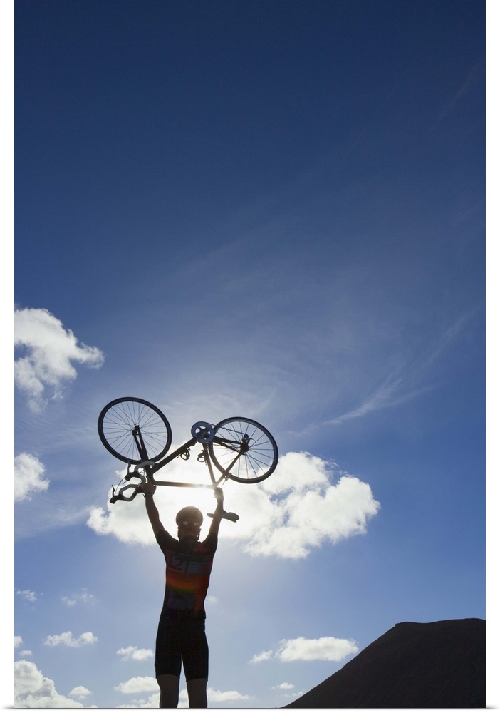 Cyclist lifting bike into the air
