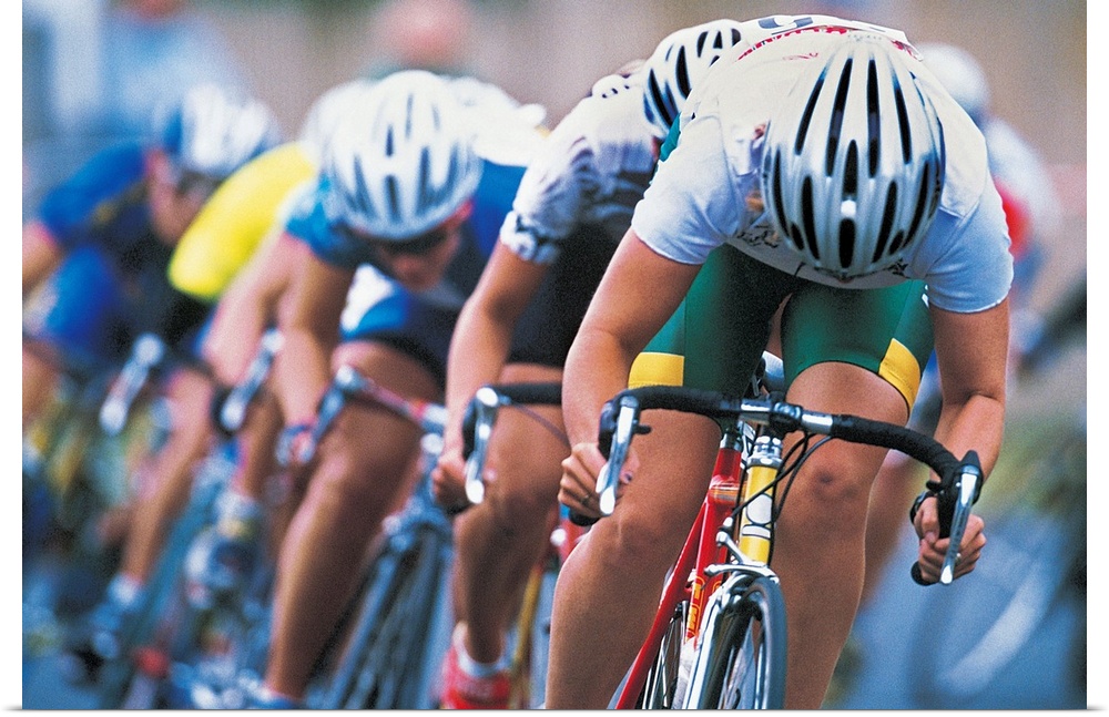 Photograph of a several racers in a bicycle race hurrying towards the finish line, with their heads down, pedaling hard.