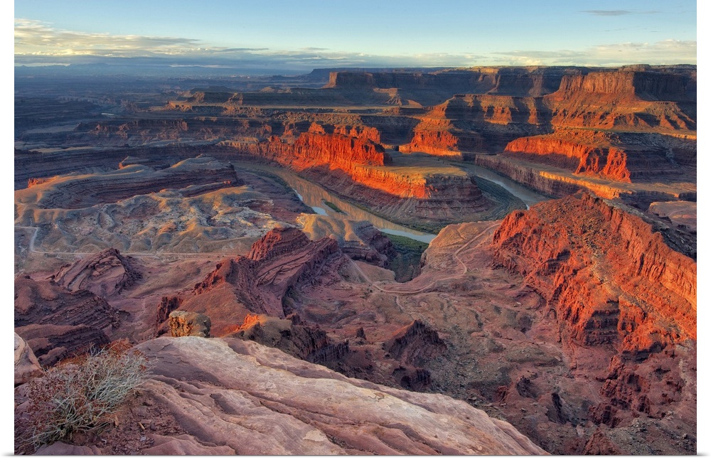 Large photo on canvas of red rock formations in Utah bathed in sunlight from a rising sun.