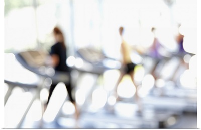 Defocused view of people on treadmills in health club