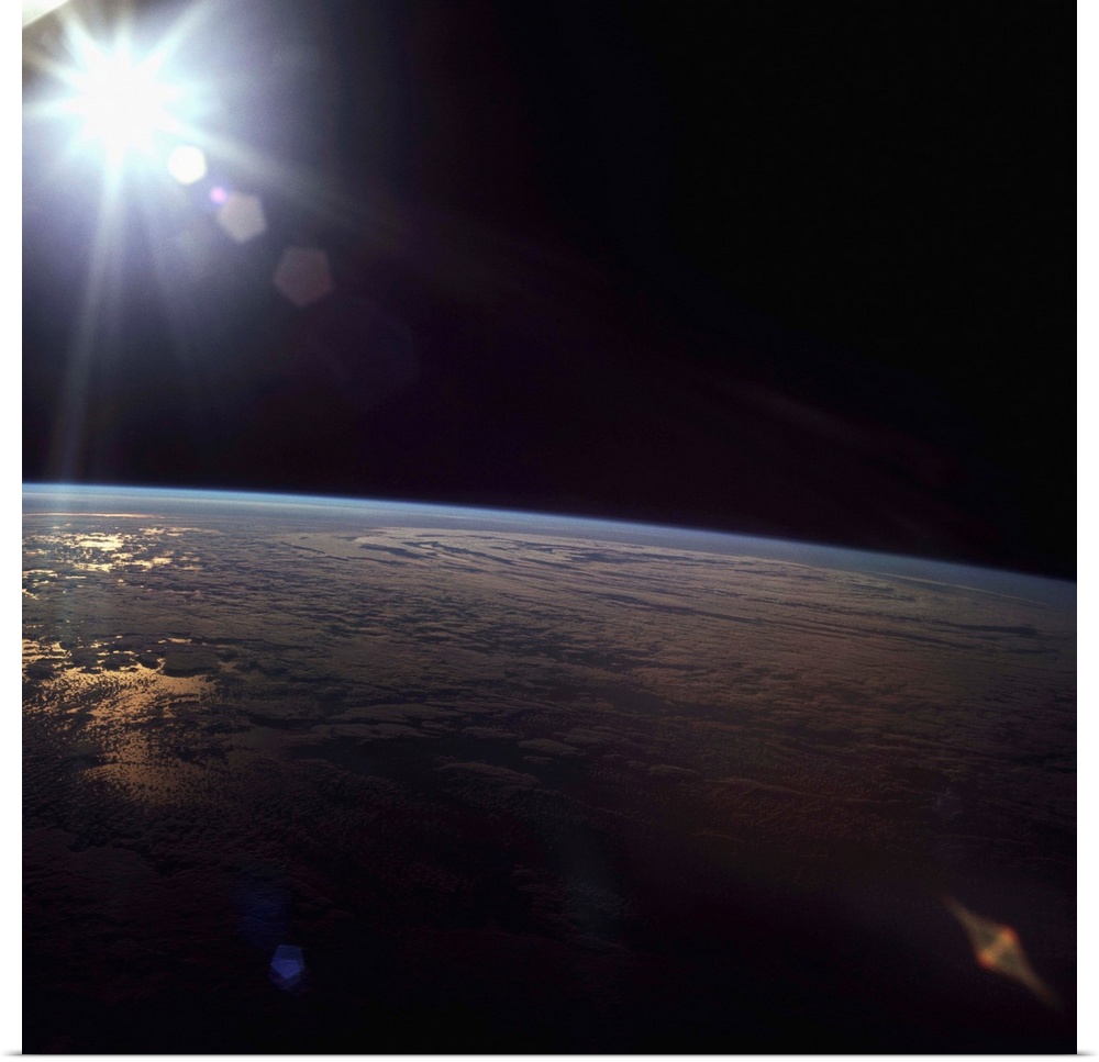 The sun shine on the surface of the Earth, seen from the Apollo 11 spacecraft. | Location: aboard Apollo 11, Earth orbit.