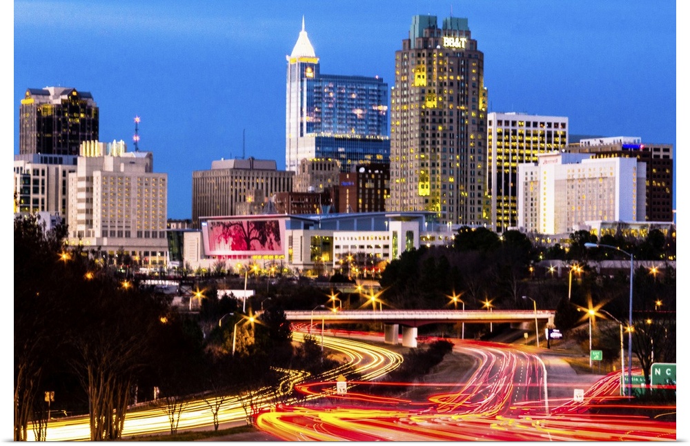Blue hour in downtown Raleigh, North Carolina, with light trails of traffic in the foreground and skyscrapers in the backg...