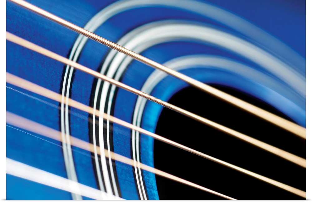 A very close view of guitar strings over the sound hole.