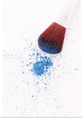 Eyeshadow brush and loose blue eyeshadow powder, close-up