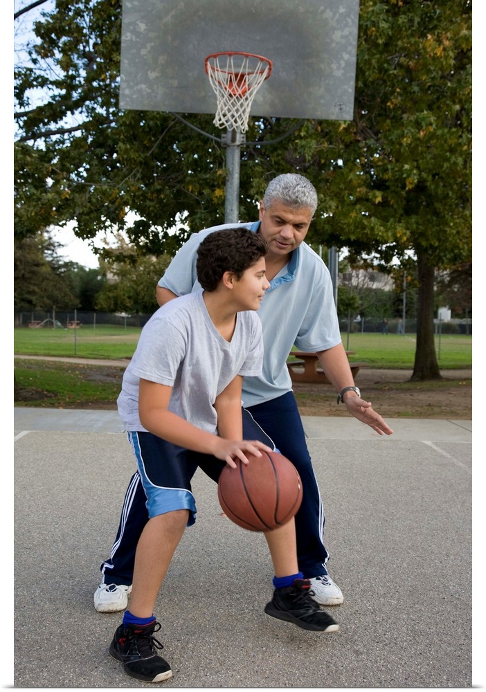 Hispanic father and son playing basketball