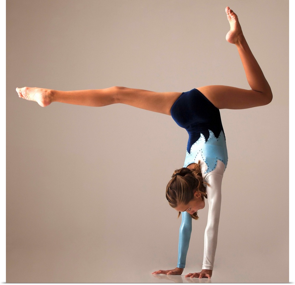 Female gymnast (12-13) performing handstand