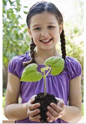 Girl holding soil and plant