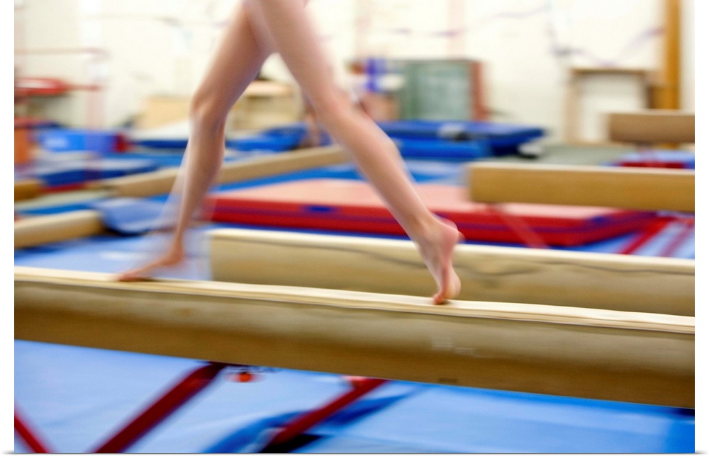 Girl (16-17) running on balance beam, low section (blurred motion)
