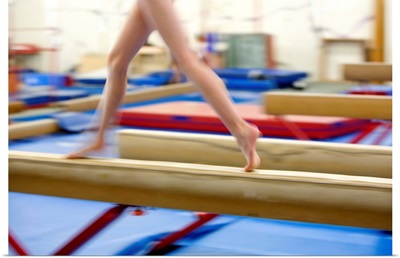 Girl running on balance beam, low section