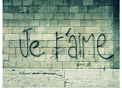 Graffiti on a wall in Paris reads 'Je t'aime' or 'I love you' in English.