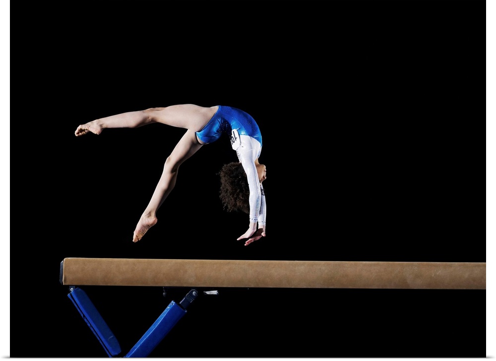 Gymnast (9-10) flipping on balance beam, side view