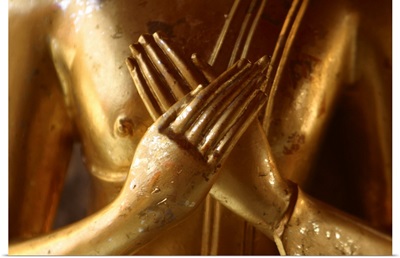 Hands of golden statue crossed over chest