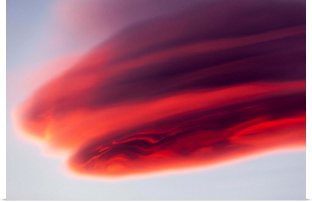 USA, Alaska, Katmai National Park, Setting sun light lenticular cloud formed by high winds above coastal mountains on late...