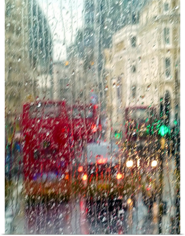 View of red double Decker buses and yellow taxis in rain in London Piccadilly Circus.
