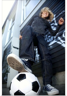 Low Angle Portrait Of Blond Boy With Soccer Ball