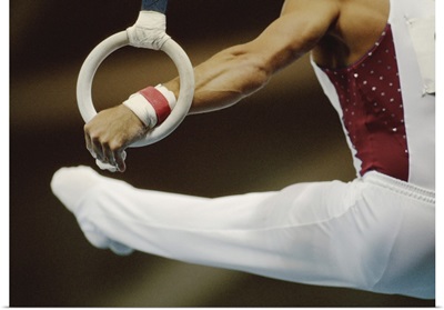 Male gymnast performing on rings, close-up