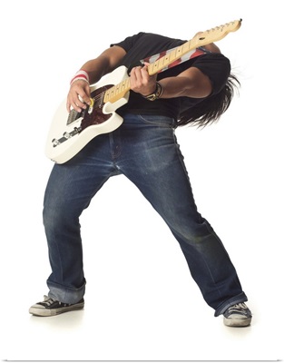 male teen leans back while playing an electric guitar
